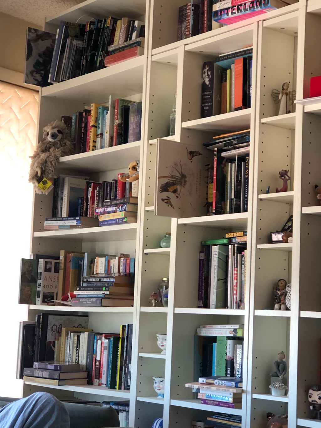 A picture of a large, white bookcase filled with books.
